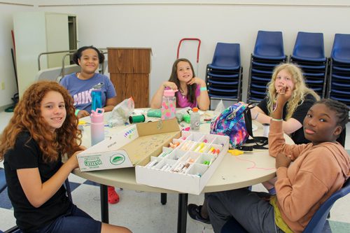 Group in cope classroom making arts and crafts